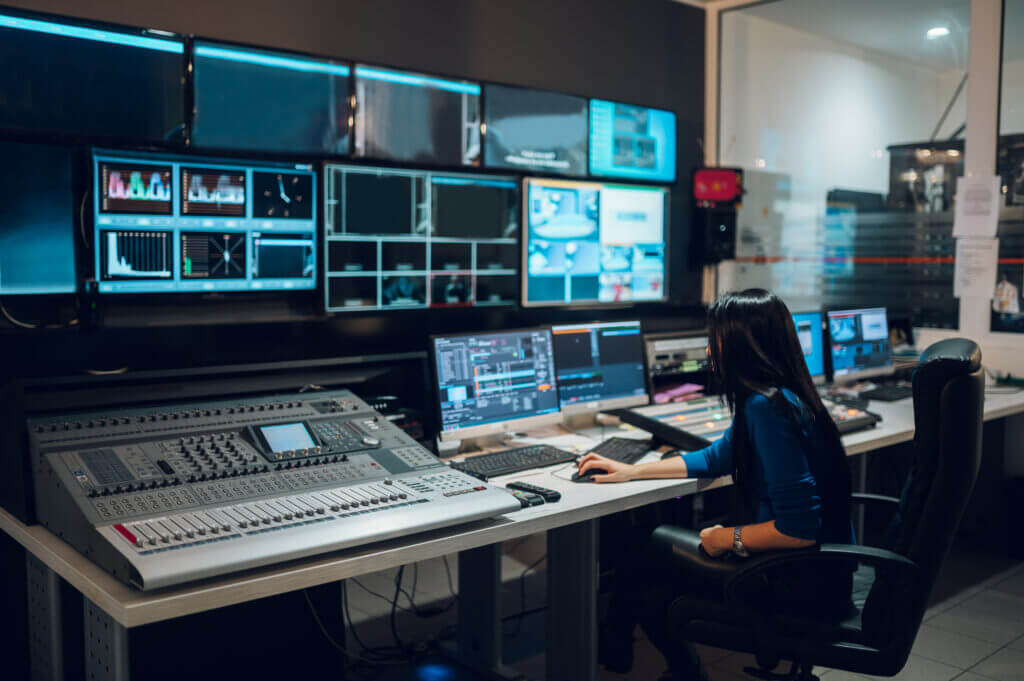 Eine Frau arbeitet im Regieraum eines Fernsehsenders