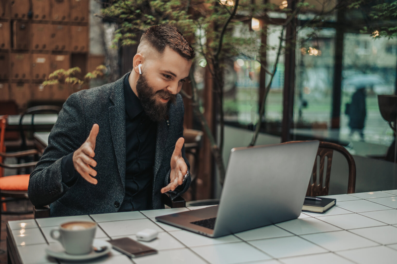 Mann vor Laptop mit gedolmetschter Webex-Konferenz